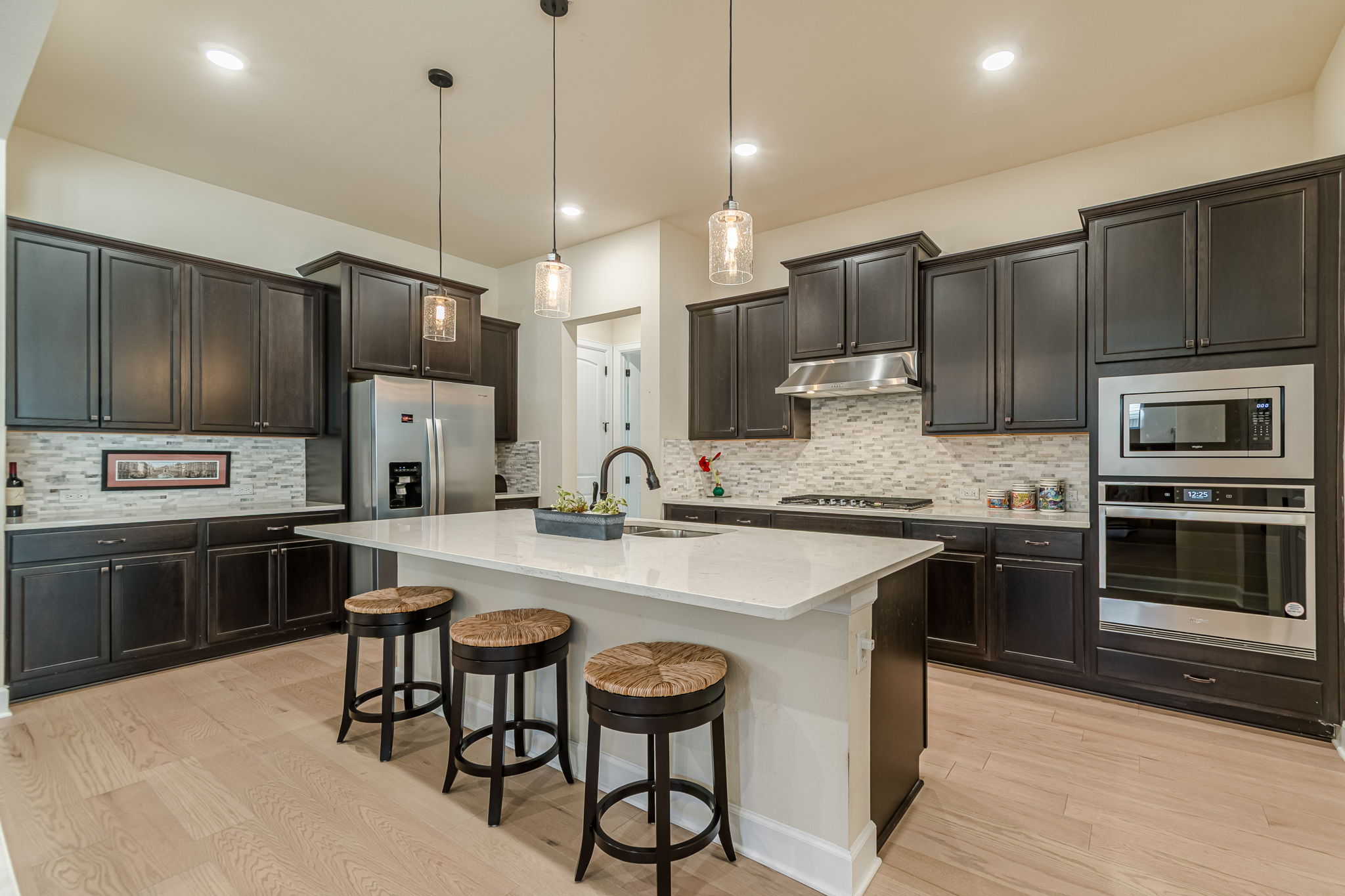136 Calming Agave Way San Marcos, TX 78666 - Photo 14 of 40 a kitchen with stainless steel appliances granite countertop a stove refrigerator sink and microwave