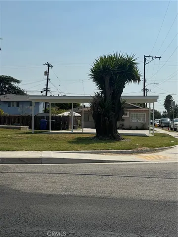a view of a house with a big yard and potted plants