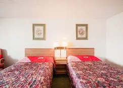 a bedroom with two beds and a lamp