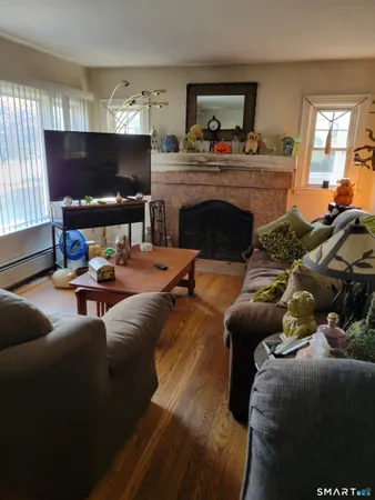 a living room with furniture a flat screen tv and a fireplace