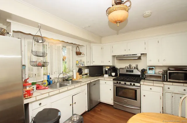 a kitchen with a sink stove and white cabinets