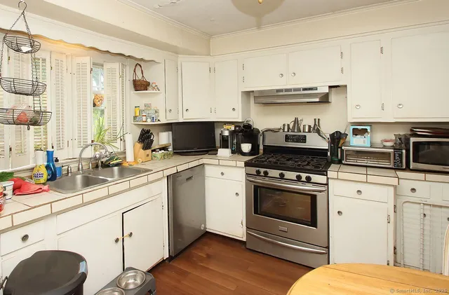 a kitchen with stainless steel appliances granite countertop a sink a stove and cabinets