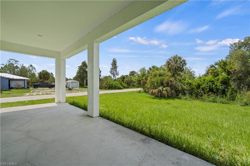 2617 3rd Street Southwest Lehigh Acres, FL 33976 - Photo 18 of 22 a view of a house with a big yard potted plants and large tree