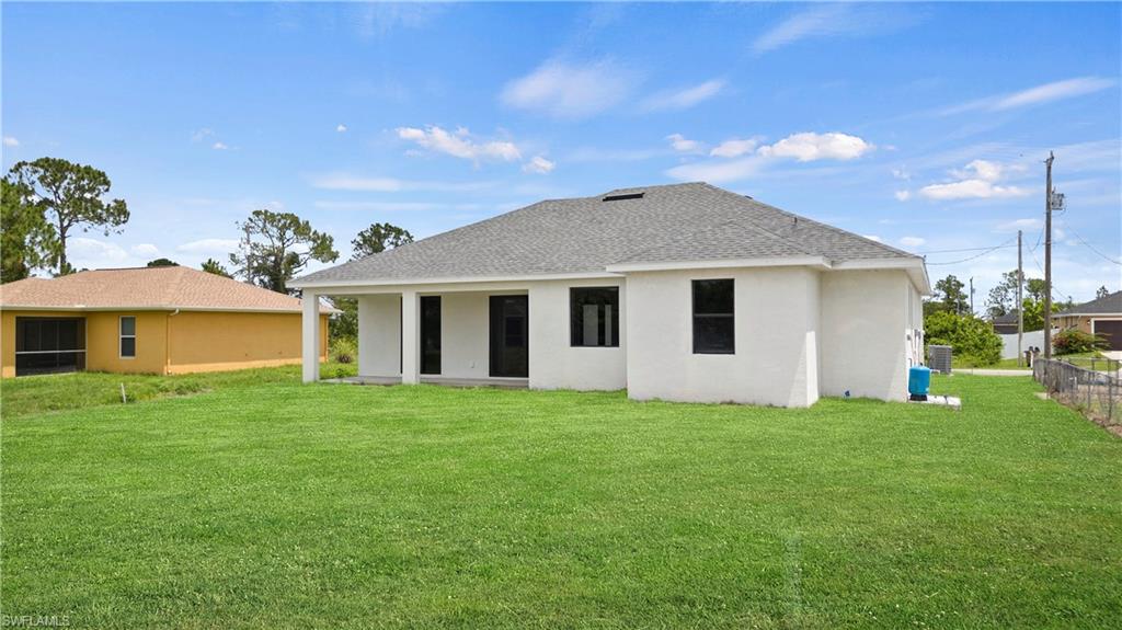 2617 3rd Street Southwest Lehigh Acres, FL 33976 - Photo 19 of 22 a yellow house with a garden