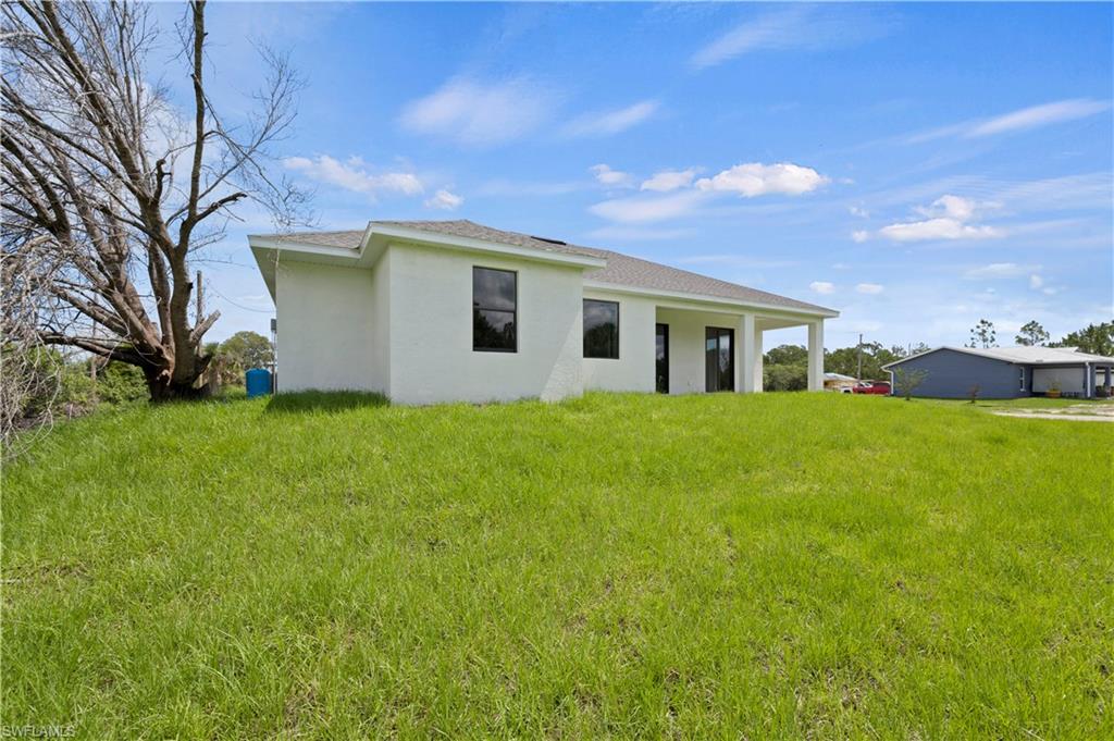 2617 3rd Street Southwest Lehigh Acres, FL 33976 - Photo 20 of 22 a front view of house with yard and green space