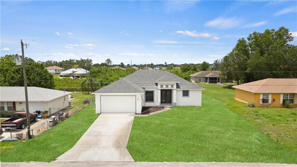 2617 3rd Street Southwest Lehigh Acres, FL 33976 - Photo 2 of 22 a view of a house with a big yard and large tree