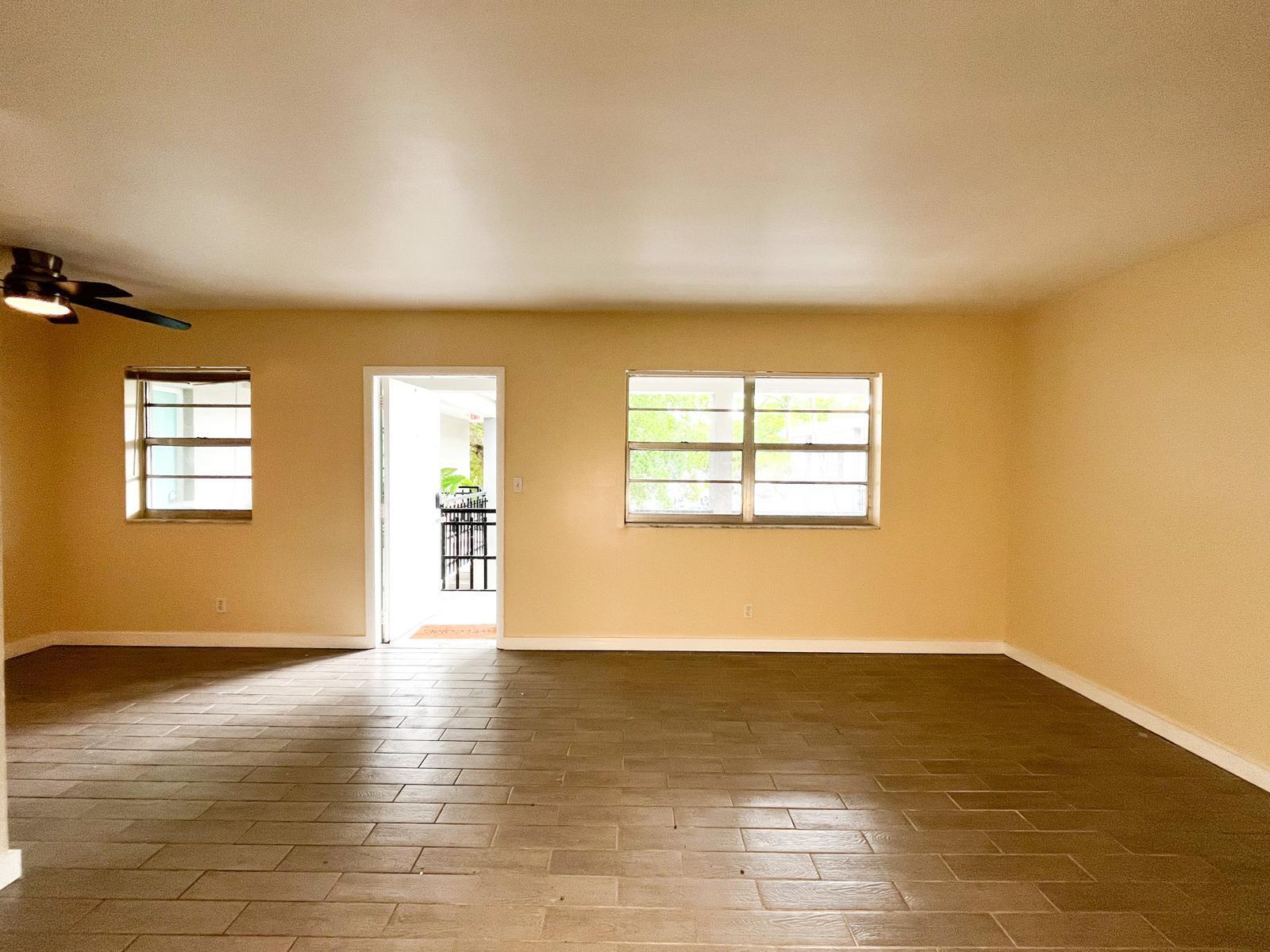 202 Lucerne Avenue, Unit 10 Lake Worth Beach, FL 33460 - Photo 14 of 16 a view of an empty room with wooden floor and a window