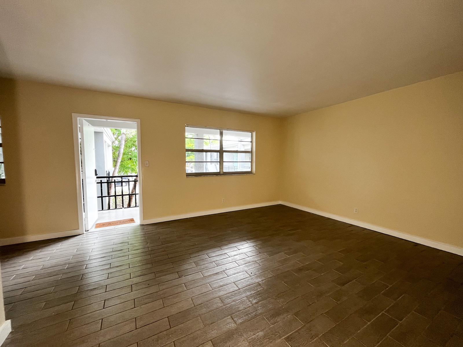 202 Lucerne Avenue, Unit 10 Lake Worth Beach, FL 33460 - Photo 15 of 16 a view of an empty room with wooden floor and a window
