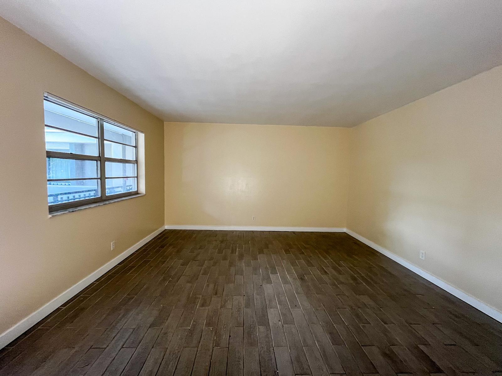 202 Lucerne Avenue, Unit 10 Lake Worth Beach, FL 33460 - Photo 6 of 16 an empty room with wooden floor and windows