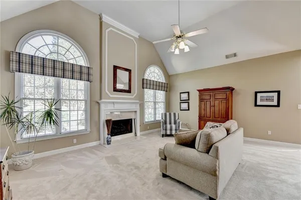 a living room with furniture a fireplace and a large window