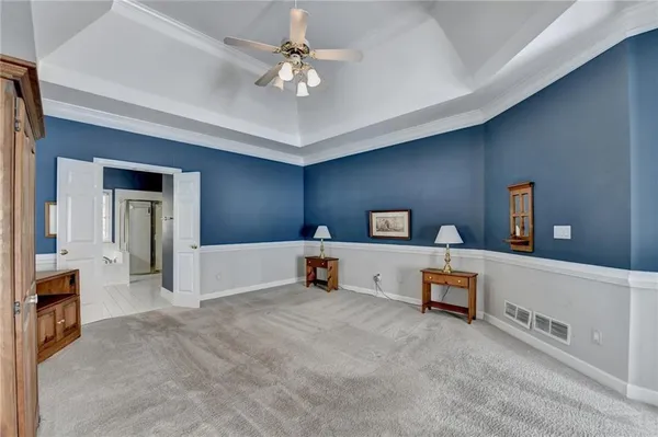 a spacious bedroom with a bed and a chandelier