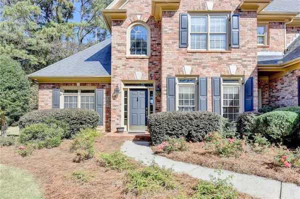 front view of a brick house with a yard