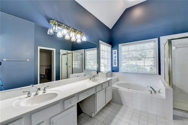 a bathroom with a large tub sink and large mirror