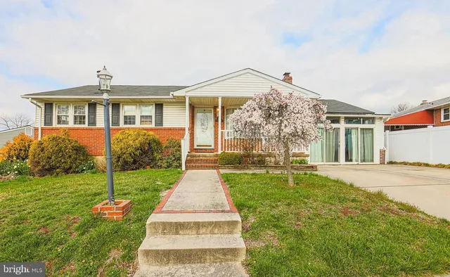 a front view of a house with a yard and potted plants