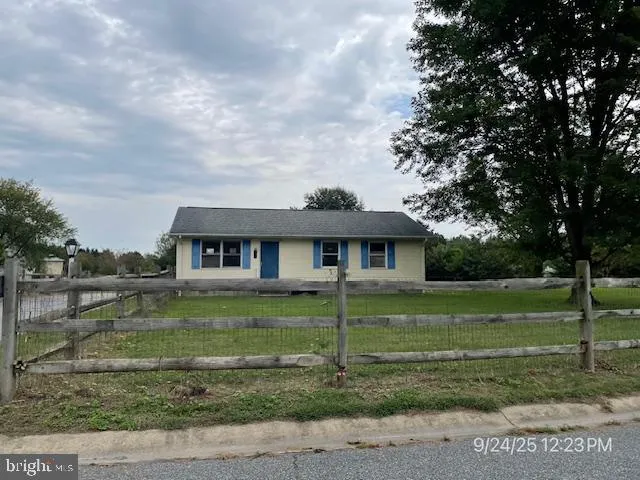 a view of a big house with a big yard and potted plants