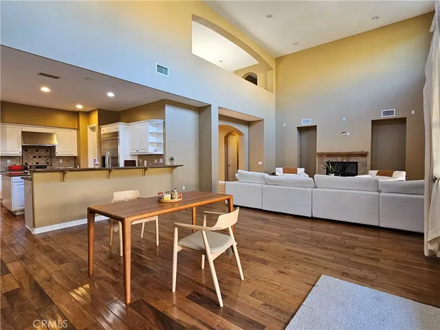 a living room with stainless steel appliances dining table furniture and kitchen view