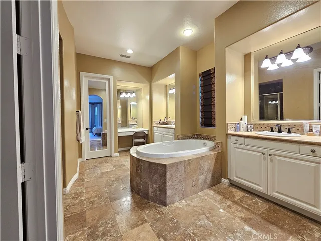 a spacious bedroom with a bed and a chandelier