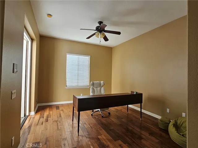 a view of a workspace with furniture and a window