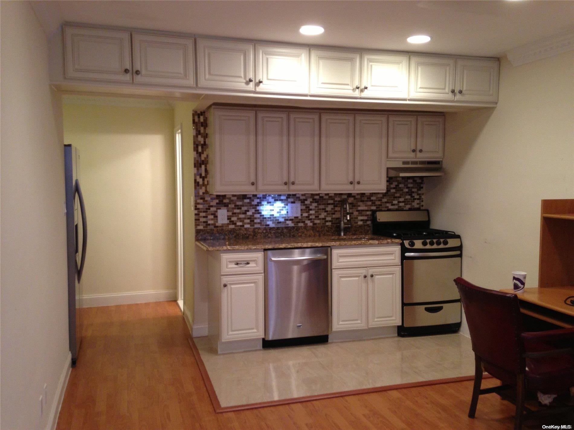 15 Canterbury Road, Unit C13 Great Neck, NY 11021 - Photo 11 of 12 a kitchen with stainless steel appliances granite countertop a refrigerator and a stove top oven