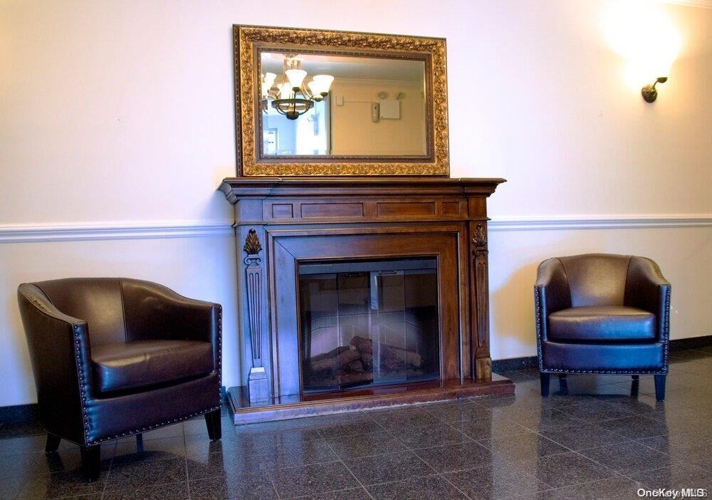 15 Canterbury Road, Unit C13 Great Neck, NY 11021 - Photo 3 of 12 a living room with furniture and a fireplace