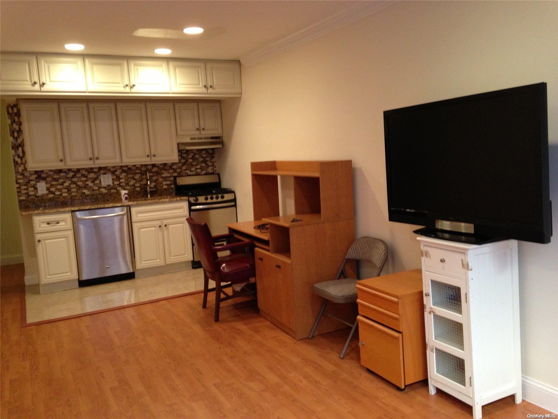 15 Canterbury Road, Unit C13 Great Neck, NY 11021 - Photo 6 of 12 a kitchen with stainless steel appliances kitchen island granite countertop a stove and a microwave