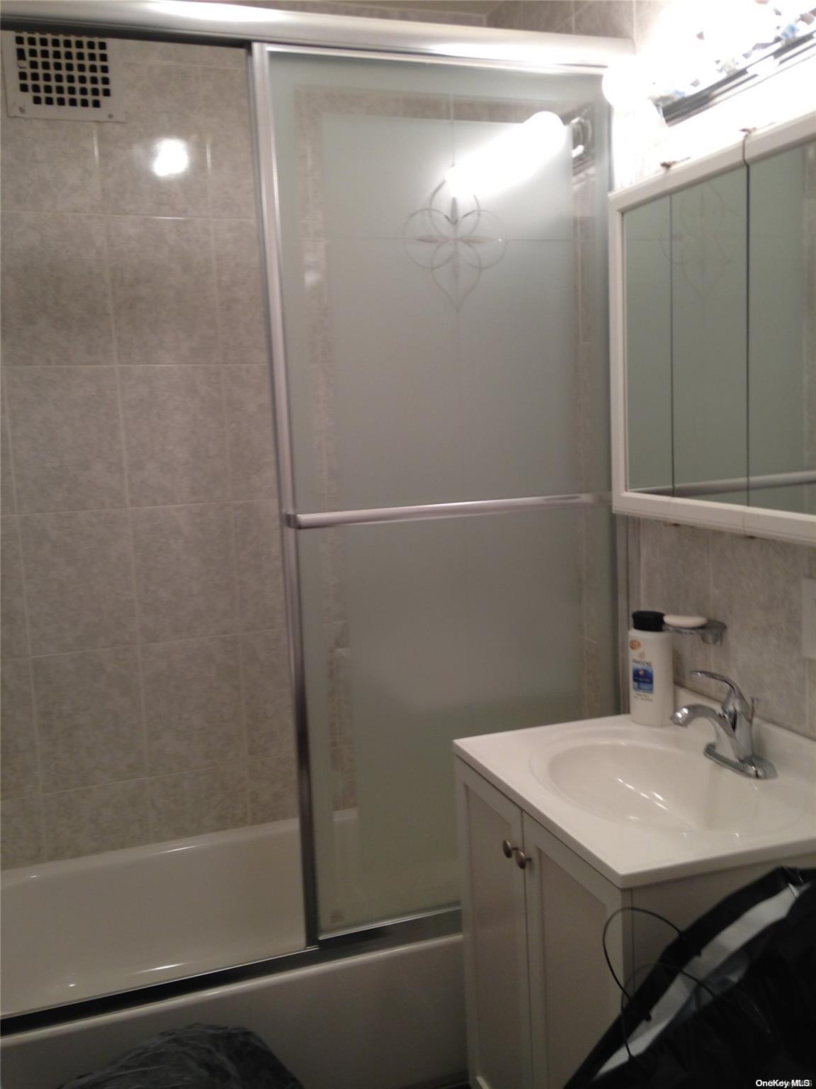 15 Canterbury Road, Unit C13 Great Neck, NY 11021 - Photo 8 of 12 a bathroom with a sink and mirror