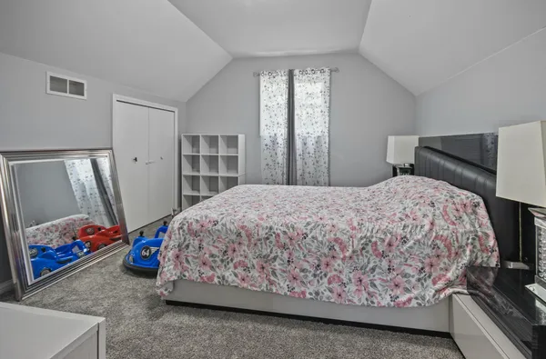 a bed sitting in a bedroom next to a window