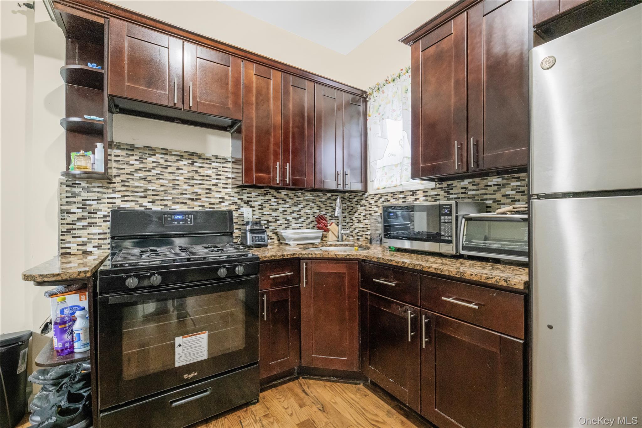 621 Faile Street Bronx, NY 10474 - Photo 12 of 32 a kitchen with kitchen island granite countertop wooden cabinets and a stove top oven
