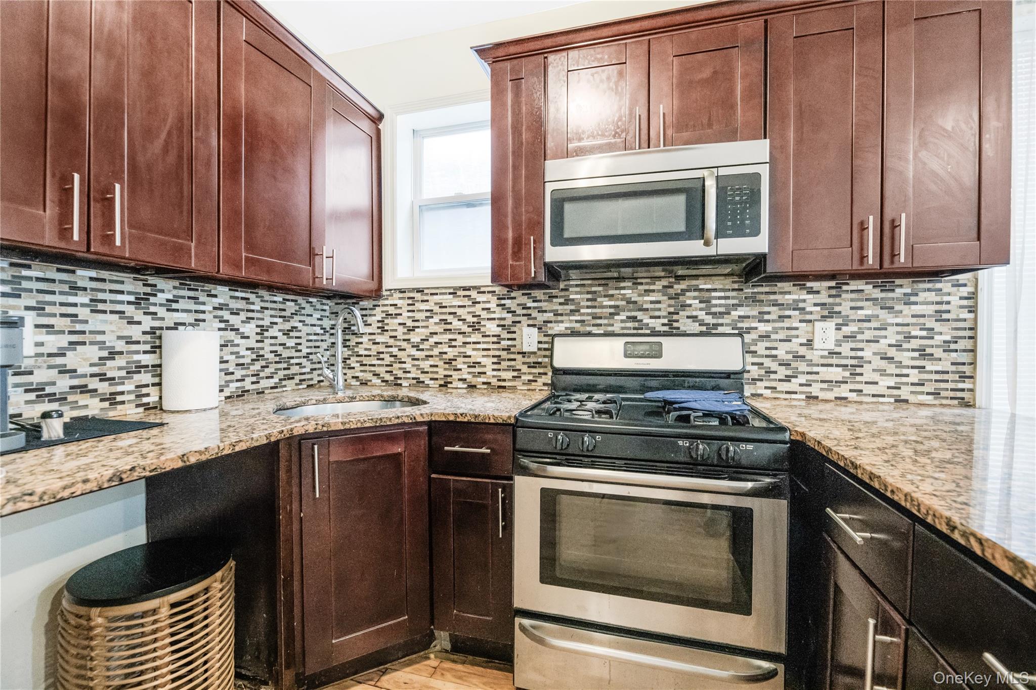 621 Faile Street Bronx, NY 10474 - Photo 21 of 32 a kitchen with granite countertop cabinets stove top oven and microwave