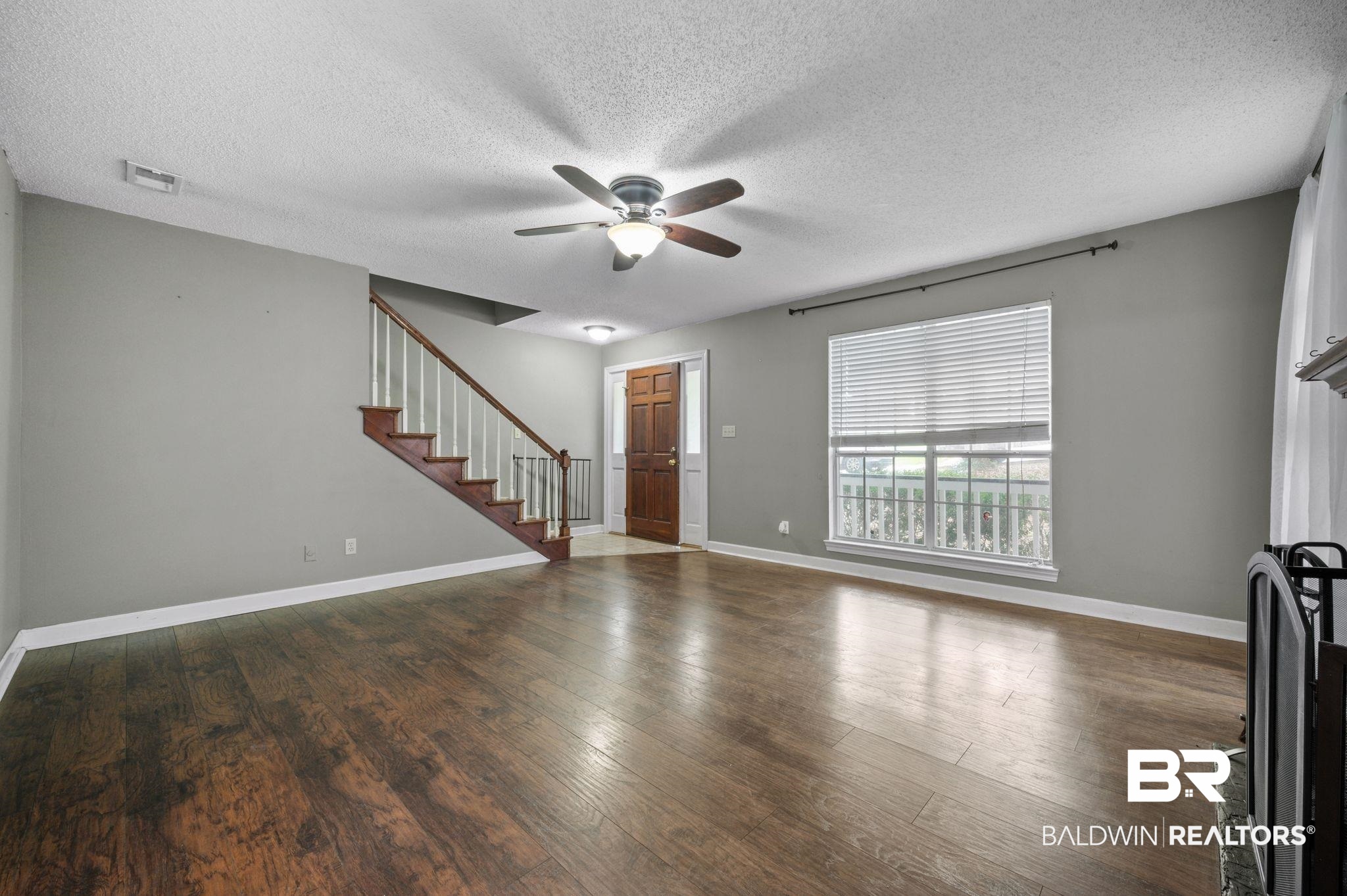 100 Montclair Loop Daphne, AL 36526 - Photo 25 of 39 Unfurnished living room featuring a textured ceiling, ceiling fan, and dark hardwood / wood-style floors