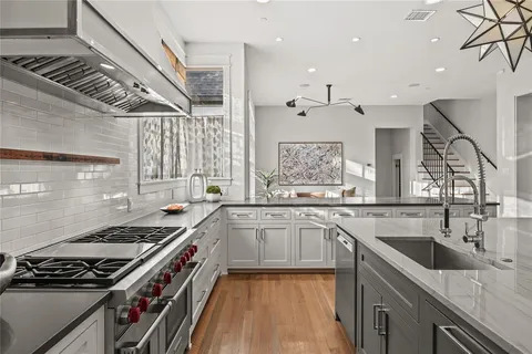 a kitchen with stainless steel appliances granite countertop a sink stove and cabinets