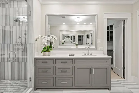 a bathroom with a granite countertop sink a mirror and a shower