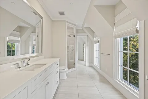 a spacious bathroom with a double vanity sink a mirror and a shower