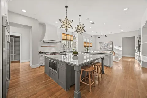 a kitchen with stainless steel appliances granite countertop a kitchen island a stove a table and chairs in it