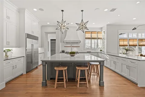 a kitchen with stainless steel appliances granite countertop a kitchen island hardwood floor and a sink