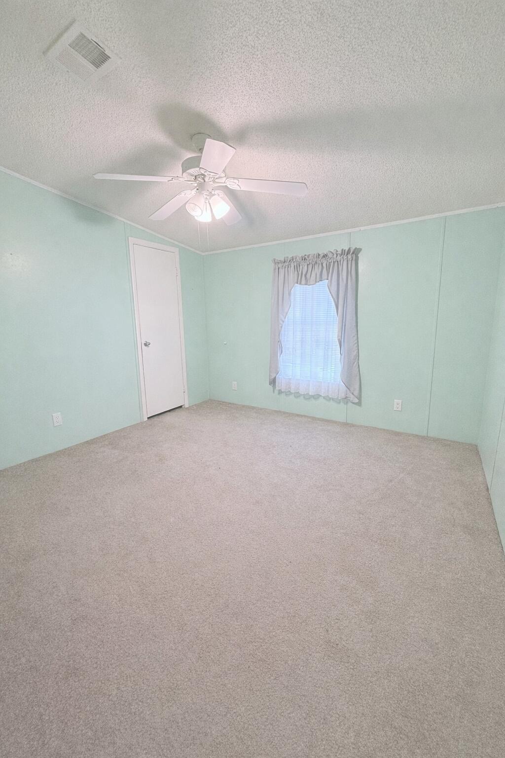 4096 Southwest 9th Way Okeechobee, FL 34974 - Photo 14 of 36 an empty room with windows and fan