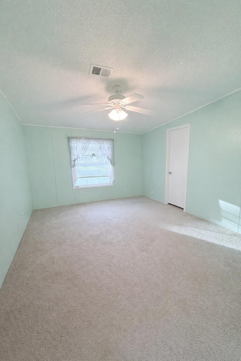 4096 Southwest 9th Way Okeechobee, FL 34974 - Photo 15 of 36 a view of a big room with windows and chandelier fan