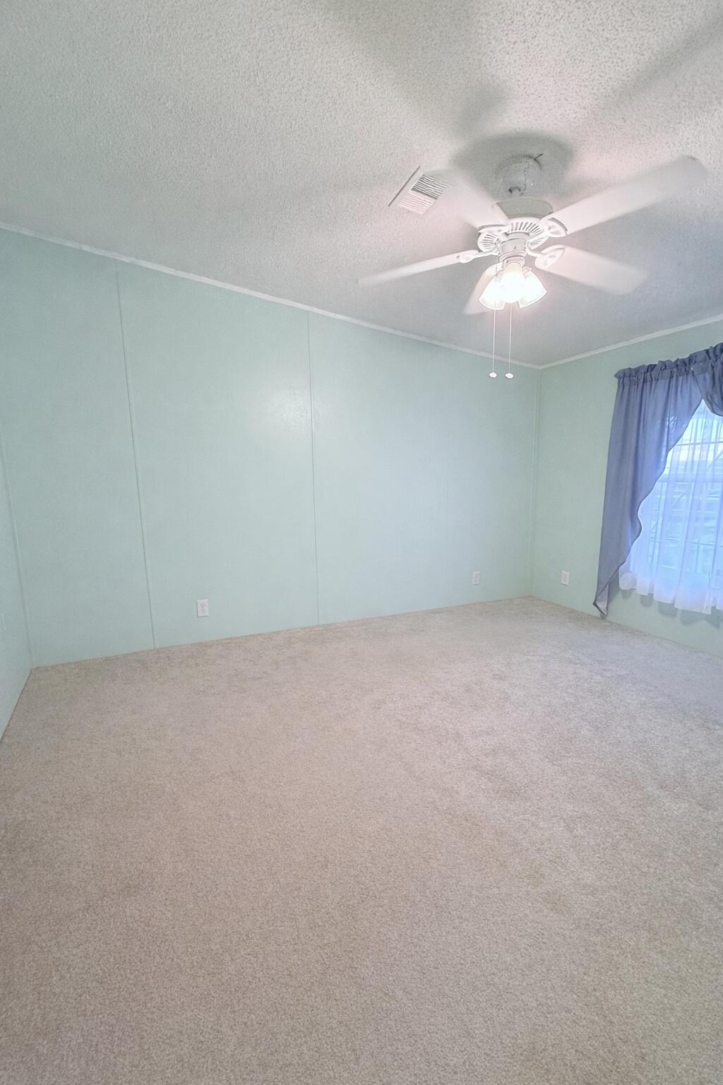 4096 Southwest 9th Way Okeechobee, FL 34974 - Photo 16 of 36 an empty room with a ceiling fan and wooden floor