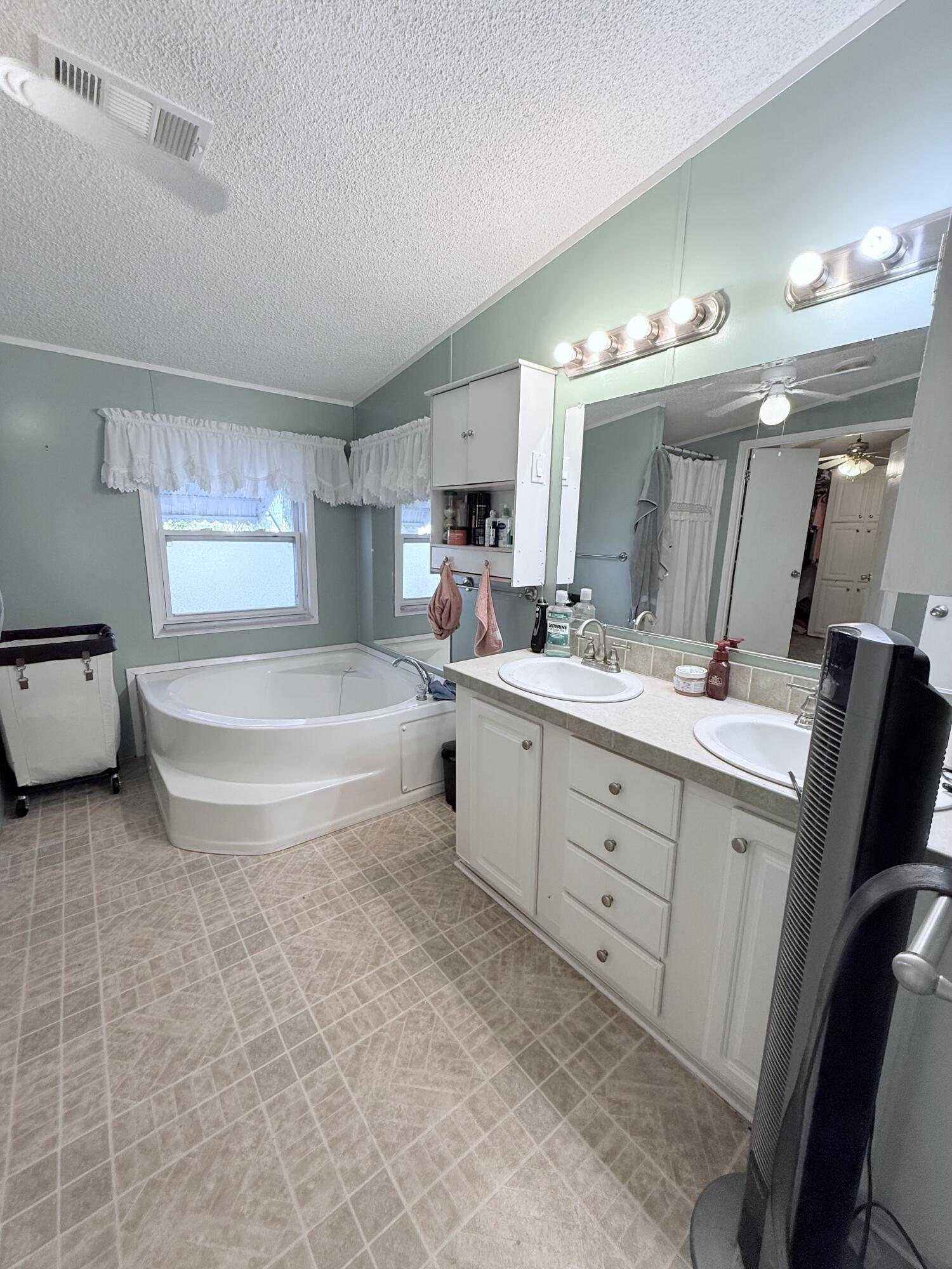 4096 Southwest 9th Way Okeechobee, FL 34974 - Photo 19 of 36 a spacious bathroom with a double vanity sink mirror and bathtub