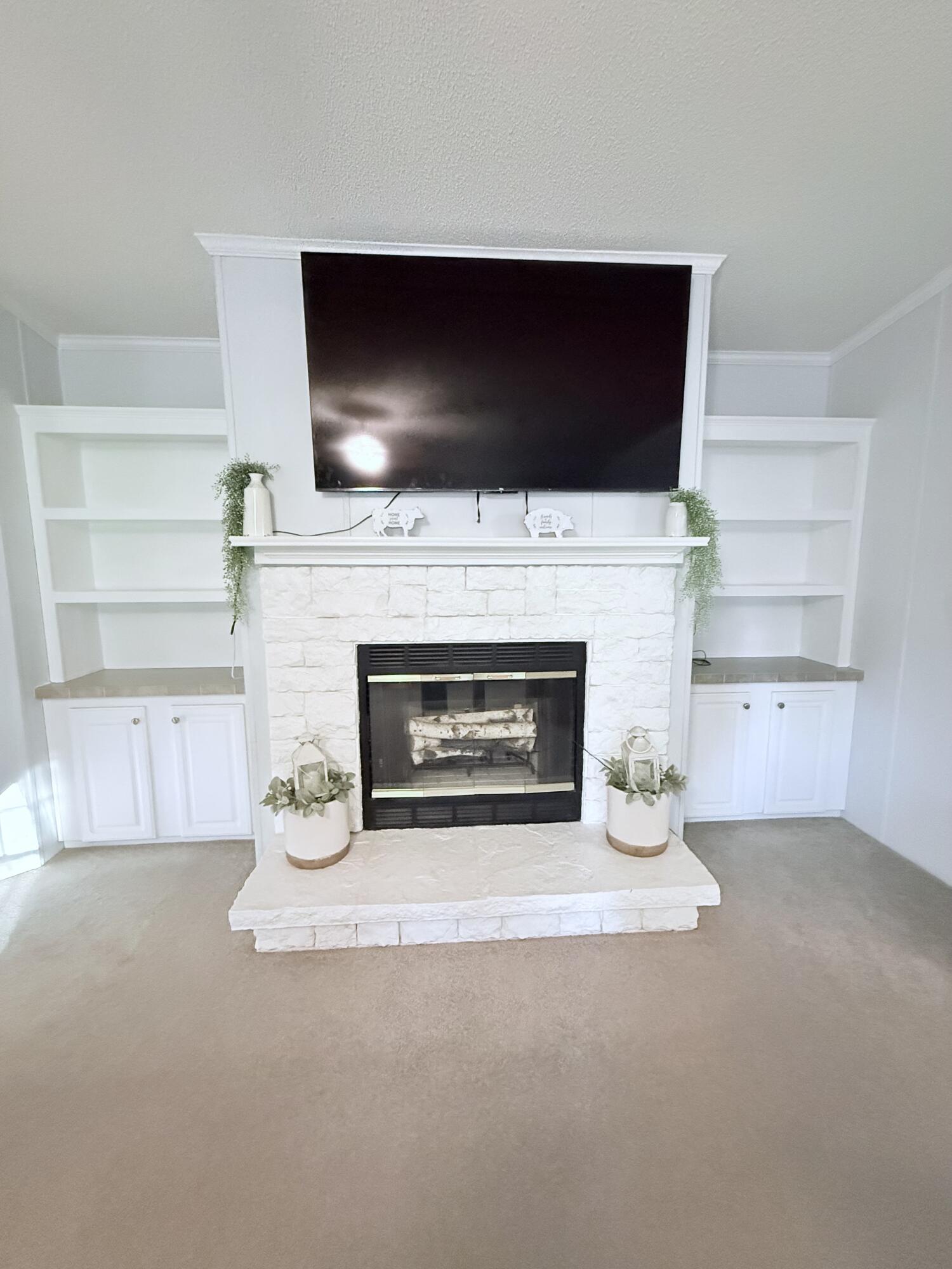 4096 Southwest 9th Way Okeechobee, FL 34974 - Photo 8 of 36 a living room with a fireplace and a flat screen tv