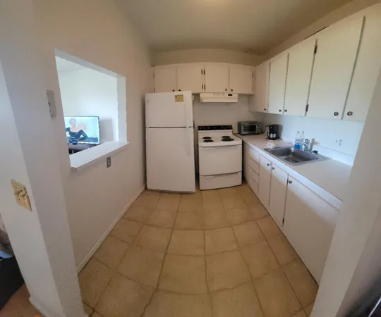 a kitchen with cabinets a refrigerator and a stove