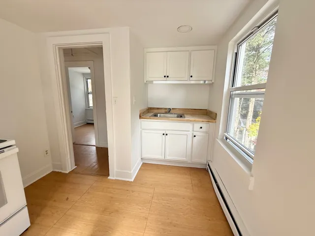 a kitchen with white cabinets and appliances