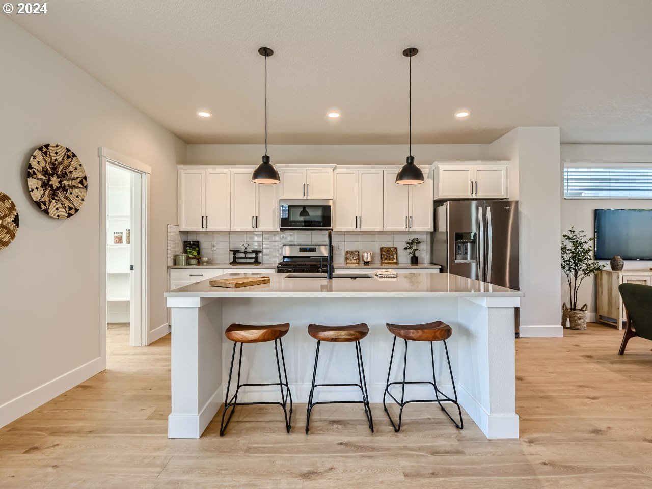20629 Southwest Boyd Court, Unit 3 Beaverton, OR 97003 - Photo 23 of 46 a kitchen with stainless steel appliances kitchen island granite countertop a dining table chairs sink and wooden cabinets