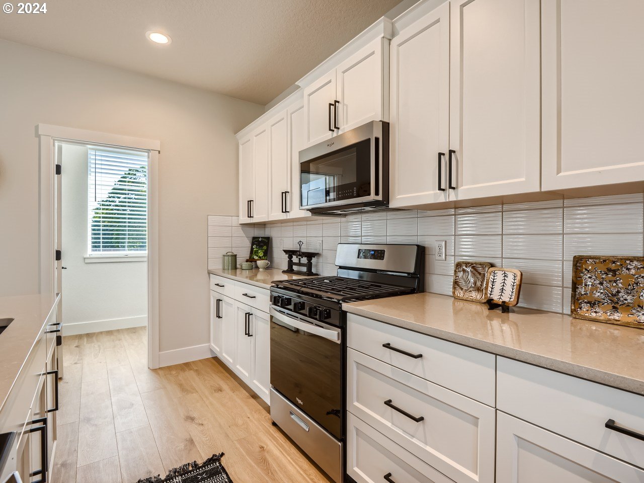 20629 Southwest Boyd Court, Unit 3 Beaverton, OR 97003 - Photo 24 of 46 a kitchen with stainless steel appliances granite countertop white cabinets a sink a stove and a refrigerator