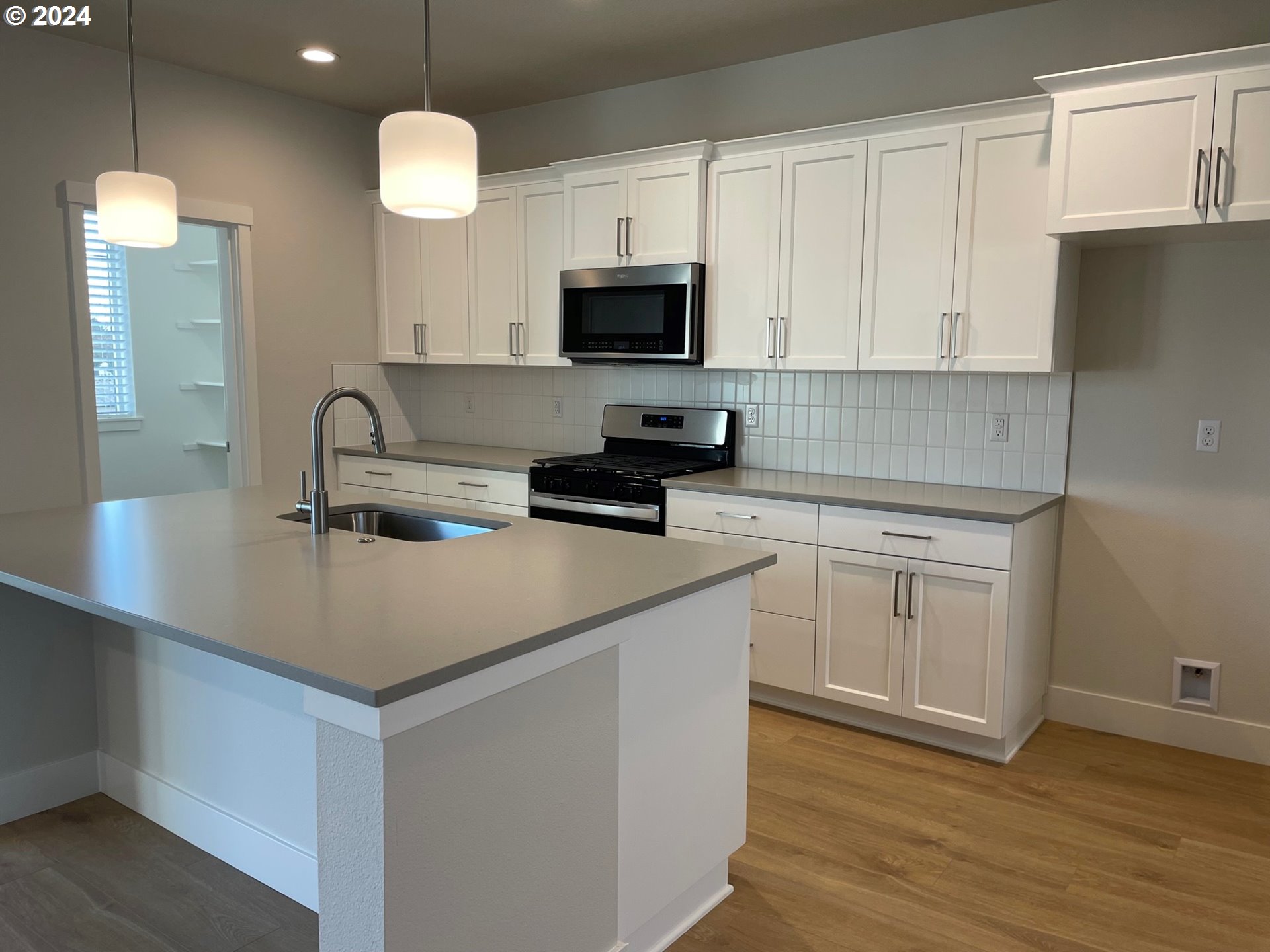 20629 Southwest Boyd Court, Unit 3 Beaverton, OR 97003 - Photo 3 of 46 a kitchen with a sink a microwave a stove and refrigerator