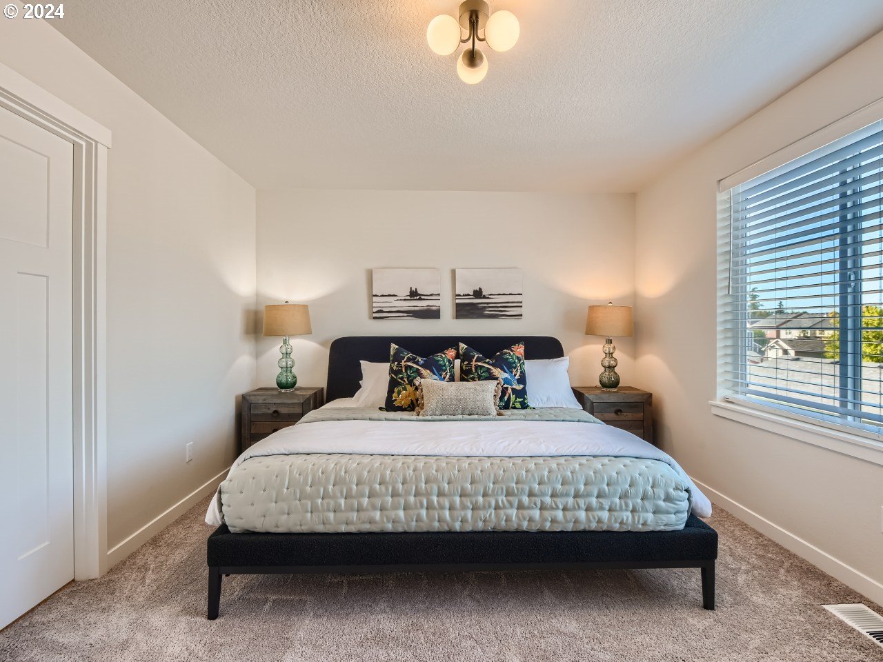 20629 Southwest Boyd Court, Unit 3 Beaverton, OR 97003 - Photo 31 of 46 a bedroom with a bed a chandelier and a window