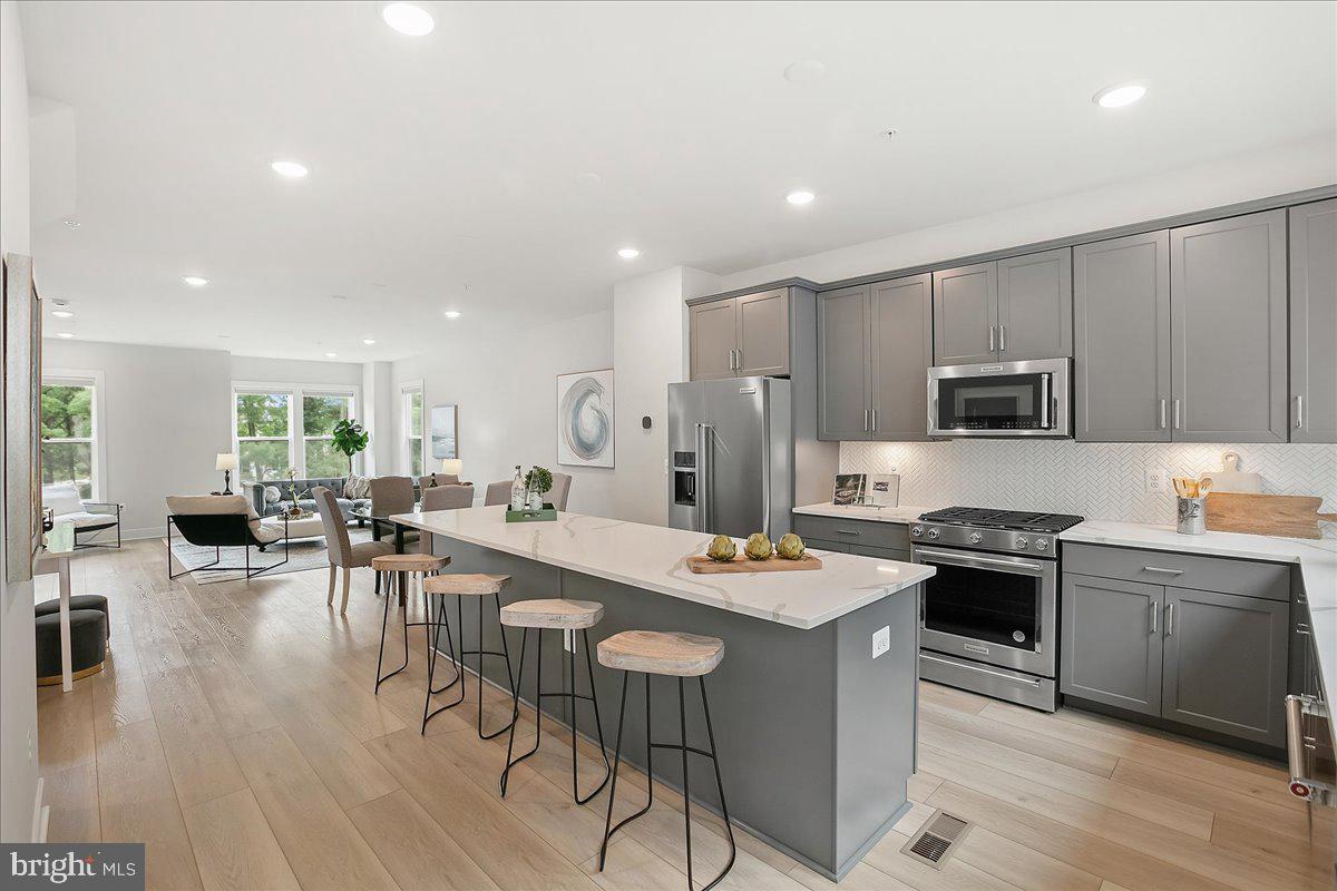 12768 Sunrise Valley Drive Reston, VA 20191 - Photo 32 of 33 a kitchen with a table chairs stove and cabinets