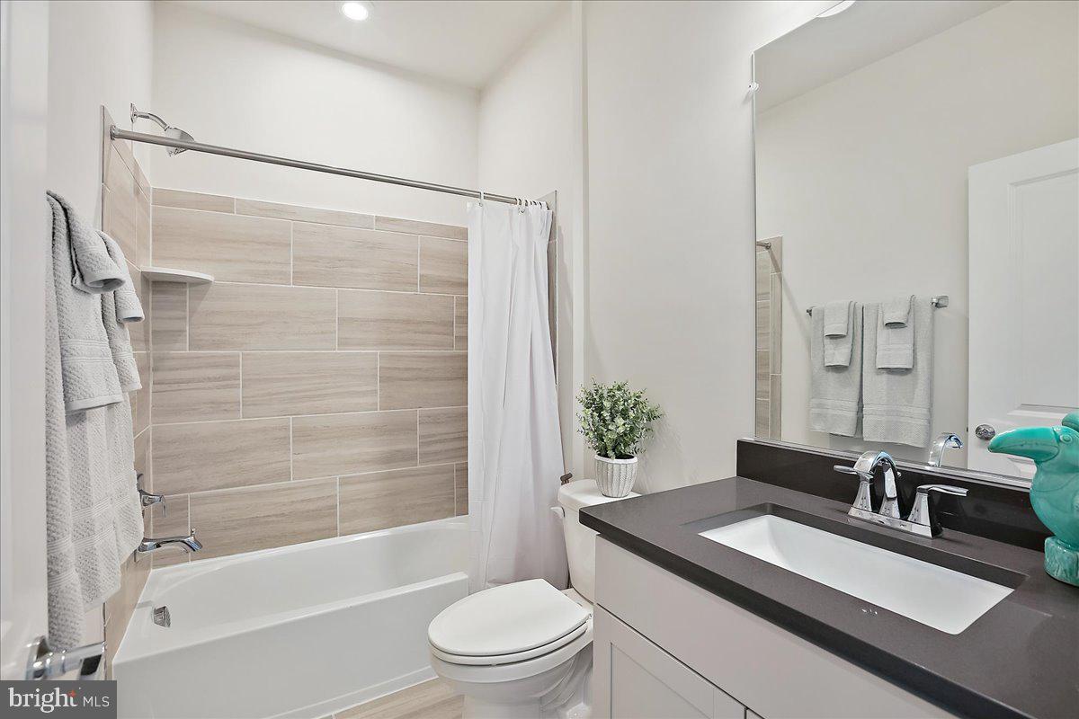 12768 Sunrise Valley Drive Reston, VA 20191 - Photo 24 of 33 a bathroom with a granite countertop sink toilet a mirror and shower