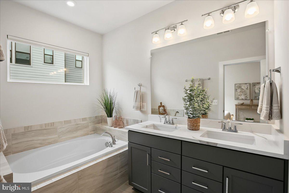 12768 Sunrise Valley Drive Reston, VA 20191 - Photo 4 of 33 a bathroom with a tub a sink and mirror