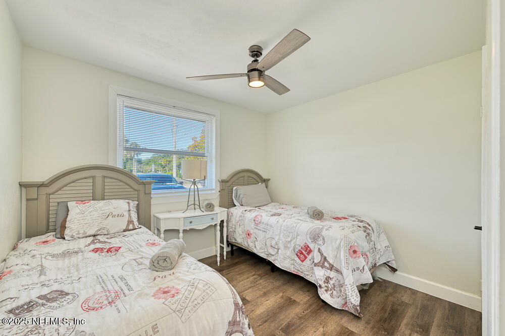 1907 Penman Road Jacksonville Beach, FL 32250 - Photo 11 of 27 a bedroom with two beds and a chandelier